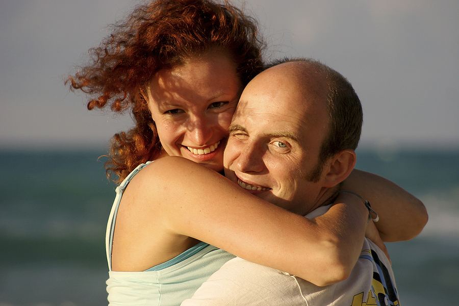 A couple embracing on a beach at sunset